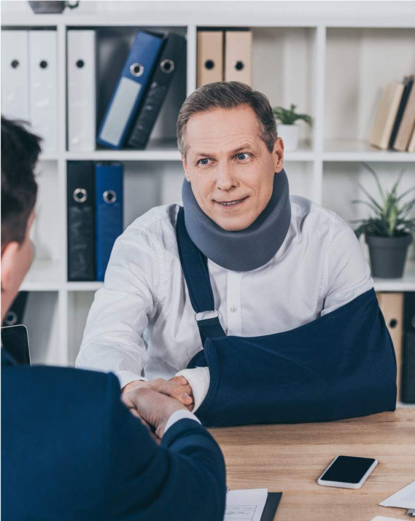 A man with his arm in a sling meeting with an attorney