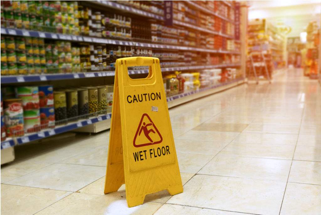 A wet floor sign on a grocery store floor